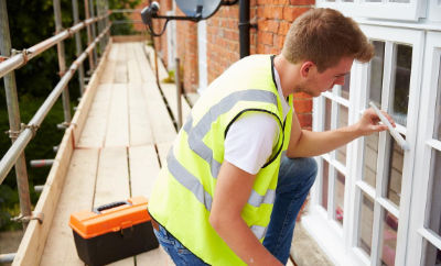 A contrctor painting a window sill